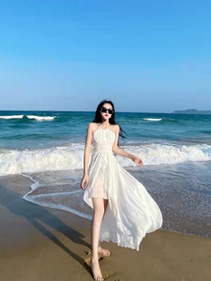 海辺の休暇のドレス、白いスーパーフェアリービーチスカート、三亜旅行服、フレンチスタイルのバックレスサスペンダードレス