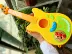 Spot Nhật Bản nhập khẩu bánh mì Superman bé ukulele guitar nhỏ đồ chơi trẻ em âm nhạc có thể chơi nhạc cụ